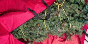 veliko umjetno božićno drvce smješteno u crvenu najlonsku vrećicu s patentnim zatvaračem