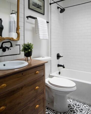 bijela kupaonica, drveni umivaonik i ladice, crne slavine i detalji