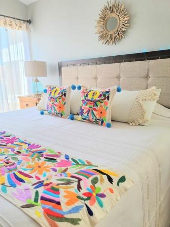 spavaća soba koju je dizajnirao soluna paz sadrži otomi vez na pokrivaču i par jastuka