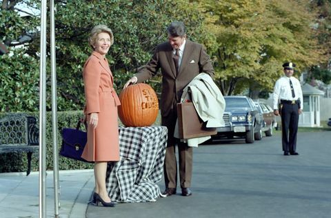 na ovoj fotografiji, predsjednik Ronald Reagan divi se bundevi uklesanoj sa sloganom " ostanite kurs" predsjednik Reagan je koristio slogan tijekom Međuizbori 1982., prva dama Nancy Reagan pozira uz bundevu. Dvije stoje ispred južnog trijema ulaza u bijeli kuća