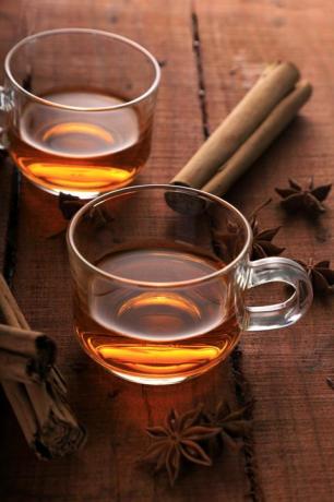 biljni čaj sa zvjezdastim anisom i cimetom u šalici na drvenom stolu