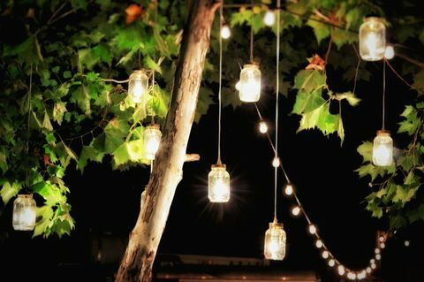 Osvijetljeni ukrasi noću vise s drveta u vrtu