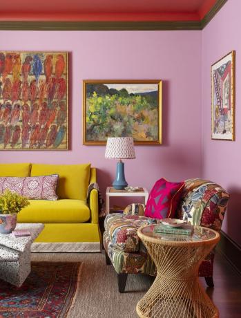 žuti kauč naspram ružičastih zidova