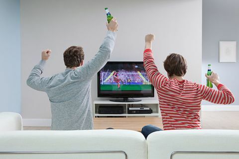 Dva muškarca gledaju nogomet na televiziji