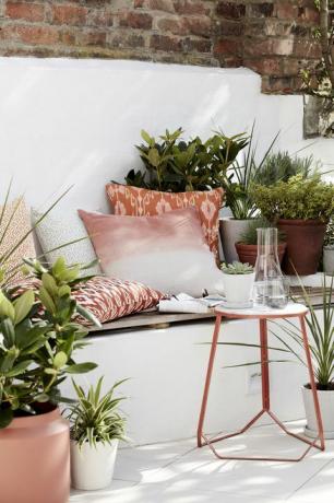 ideje za vrt, vanjski prostor za sjedenje ispunjen jastucima, biljkama i pomoćnim stolićem