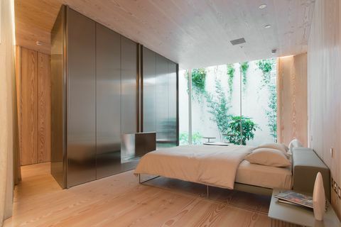 Moderna spavaća soba s bračnim krevetom i prozorima od poda do stropa