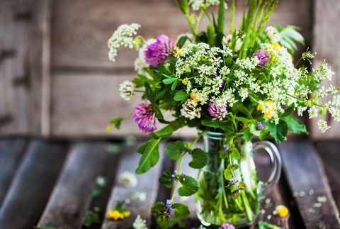 Buket divljih cvjetova u staklenoj posudi na drvenom stolu, ljetni koncept