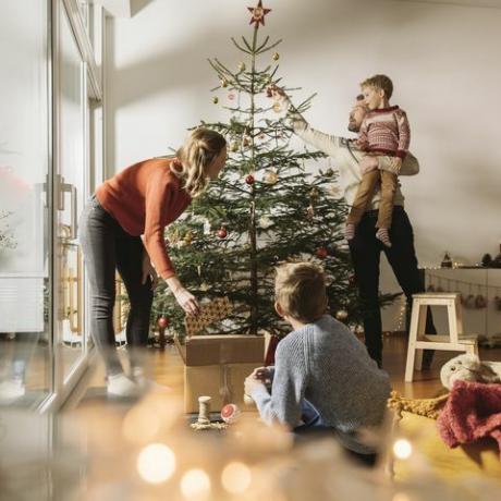 četveročlana obitelj koja ukrašava svoje božićno drvce