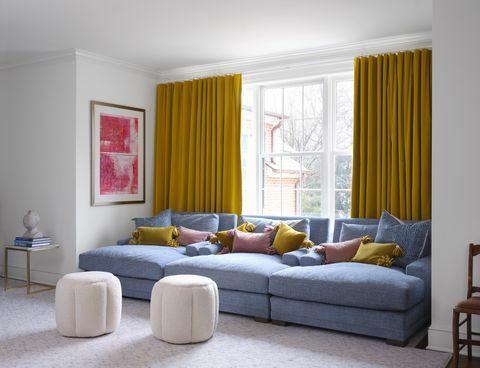 plavi kauč, žute zavjese, ružičasti i žuti jastuci