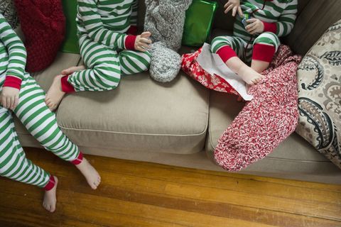 Bezličan snimak braće i sestara otvara čarape kod kuće na Božić