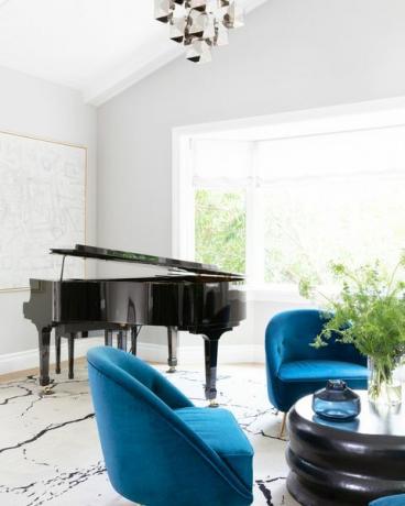dnevna soba s velikim klavirom i plavim stolicama