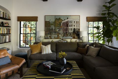 dnevni boravak, zeleni kauč, kožna stolica, žuti jastuk, bijeli zidovi
